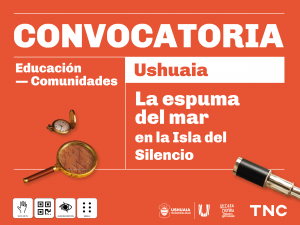 Sobre fondo naranja con letras blancas, se lee: Convocatoria. Educación. Comunidades. Ushuaia. La espuma del mar en la Isla del Silencio. A un costado, hay una brújula, una lupa que deja ver un texto manuscrito a través del vidrio y un catalejo con bordes de bronce. Debajo se destacan los pictogramas de visita táctil, código QR, audiodescripción y sistema braille. Hacia el margen inferior derecho están el escudo de la municipalidad de Ushuaia, la inicial U en mayúscula y las letras TNC de Teatro Nacional Cervantes.